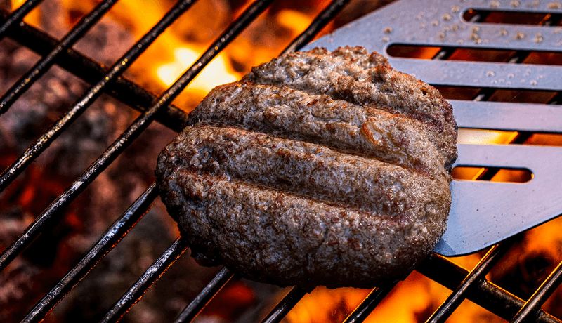 A cultivated beef patty on a grill