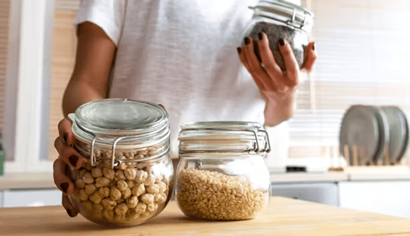 A woman storing pantry staples in air-tight containers