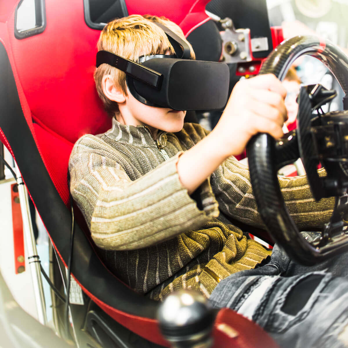 Young man using VR racing simulator